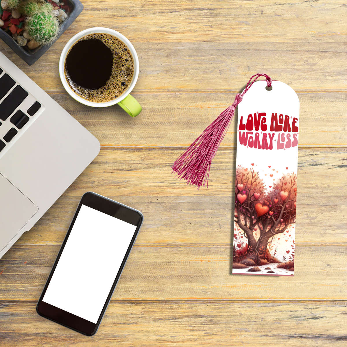 "Aluminum bookmark with the phrase ‘Love More, Worry Less,’ heart-shaped trees, floating hearts, and a red tassel."