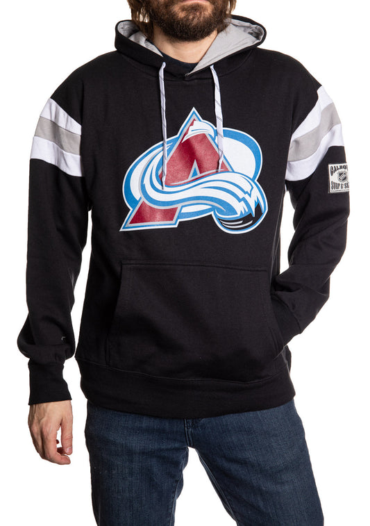 Person wearing a black hoodie with a sports team logo on a white background