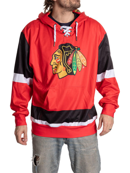 Person wearing a red and black hoodie with a sports team logo on a white background