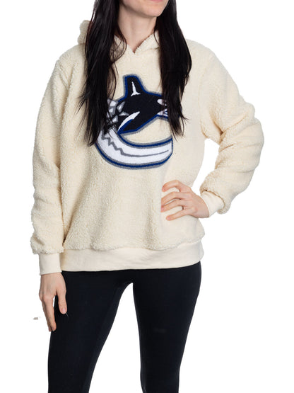 Person wearing a cream-colored hoodie with a logo on a white background