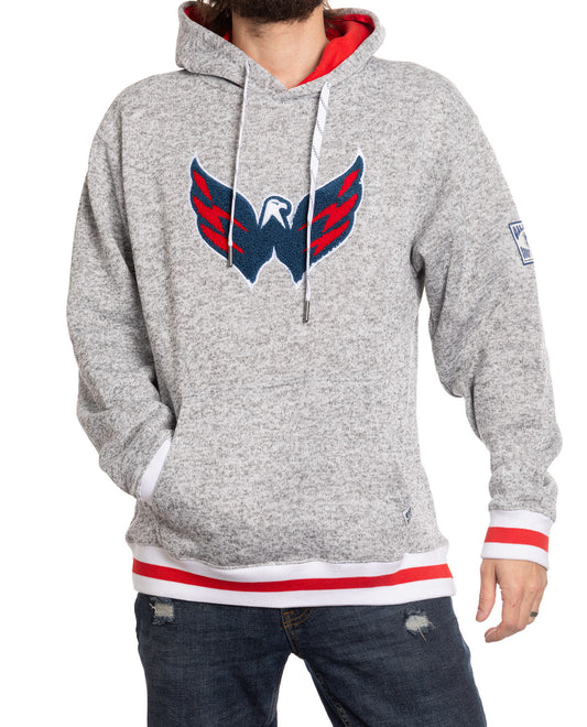 Person wearing a gray hoodie with a logo on a white background
