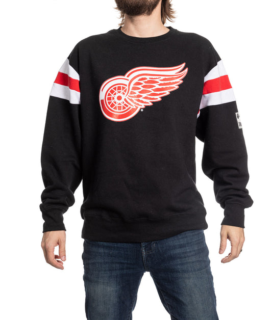 Black sweatshirt with a red and white logo worn by a person on a white background