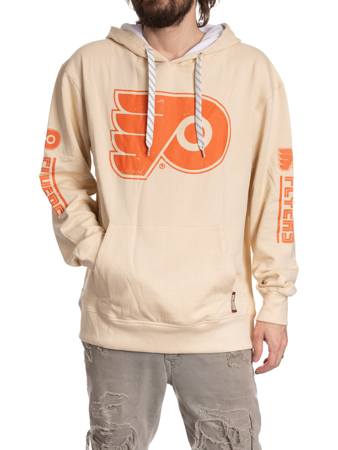 Beige hoodie with orange logo worn by a person on a white background