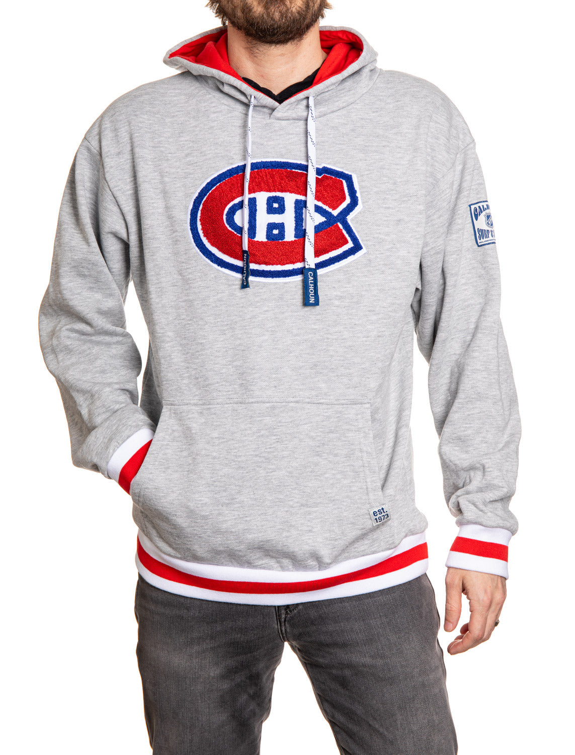 Gray hoodie with Montreal Canadiens logo worn by a person on a white background