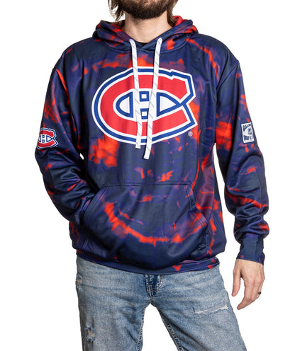 Person wearing a blue and red tie-dye hoodie with a sports team logo on a white background