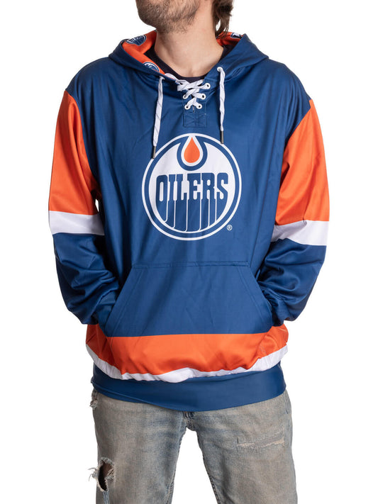 Blue and orange hoodie with Oilers logo worn by a person on a white background
