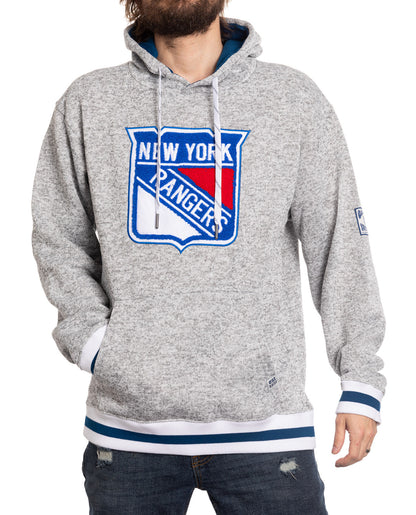 Person wearing a gray hoodie with New York Rangers logo on a white background