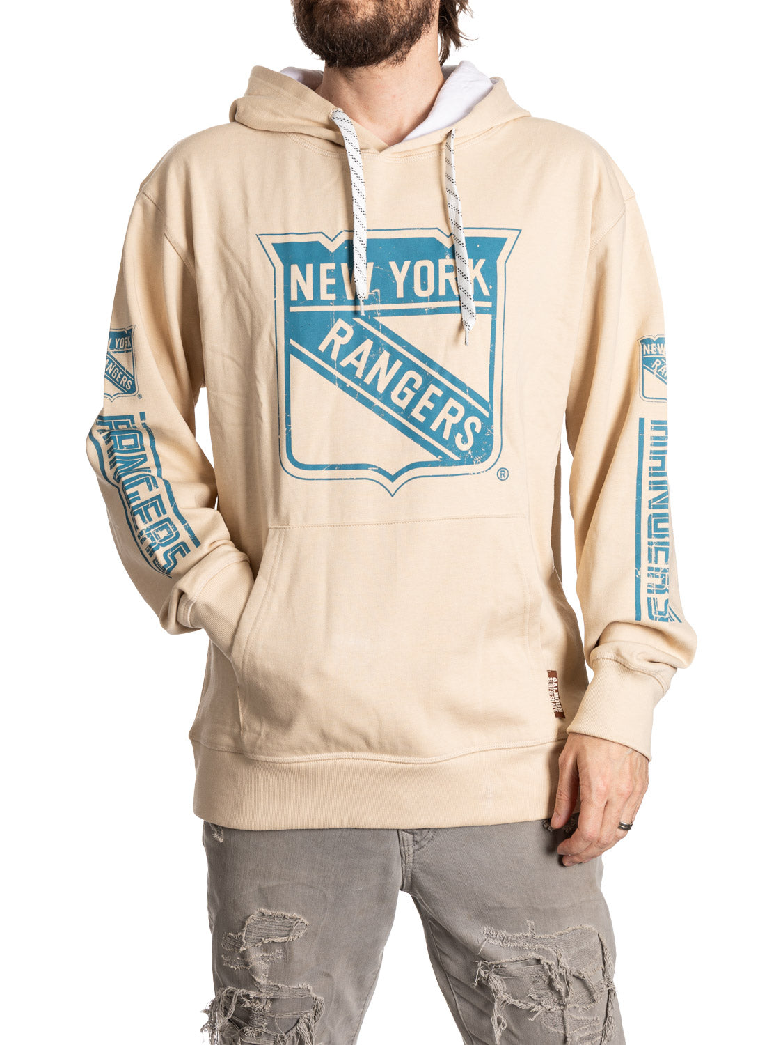 Beige hoodie with New York Rangers logo worn by a person on a white background