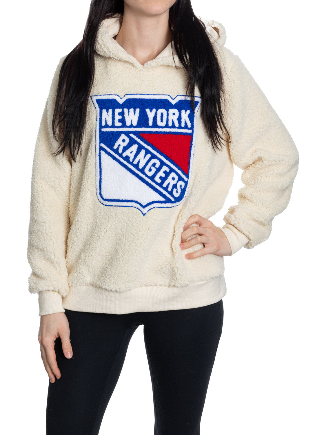 Cream-colored hoodie with New York Rangers logo worn by a person on a white background