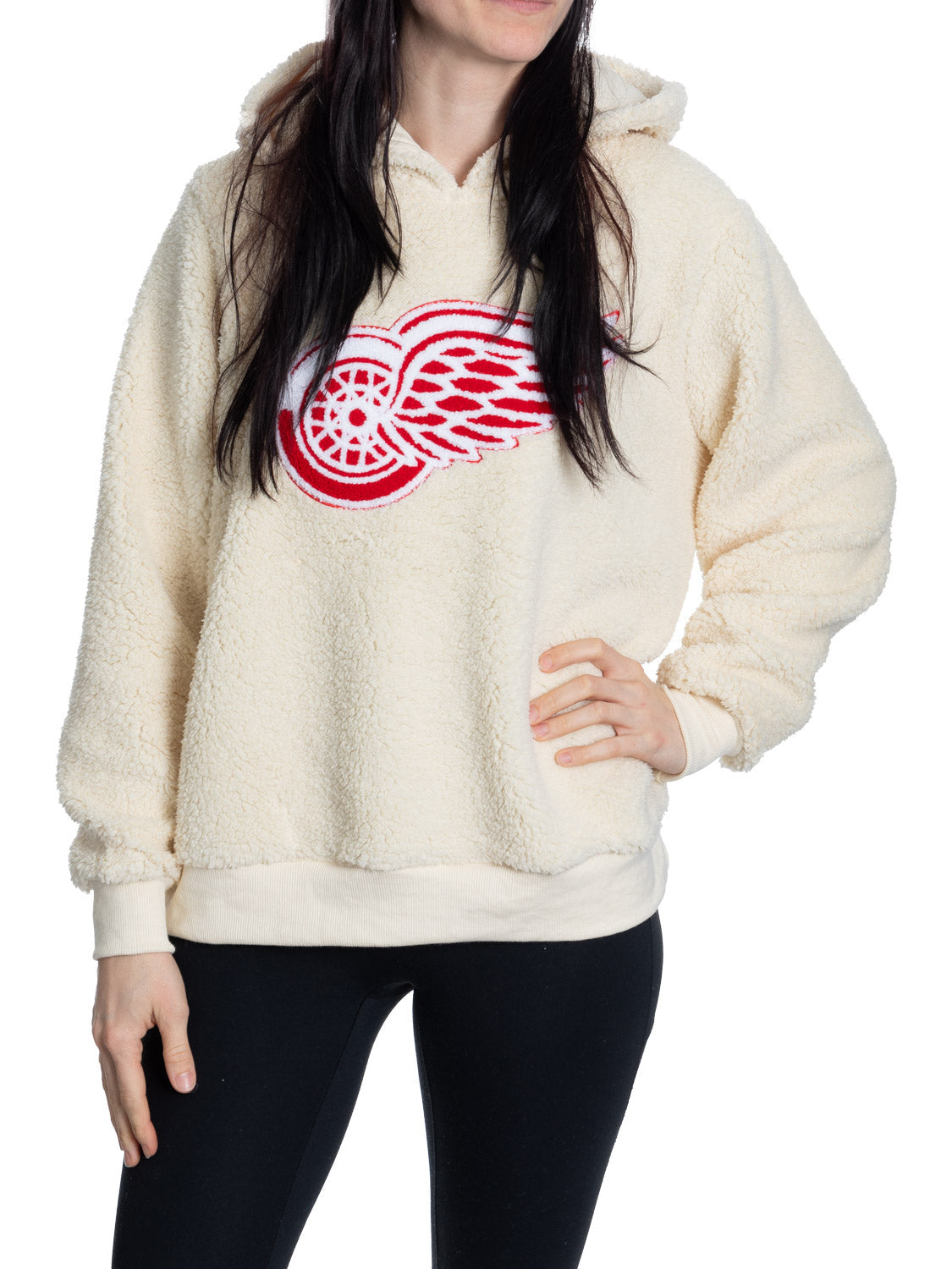 Person wearing a cream sherpa-lined hoodie with a red and black logo on a white background