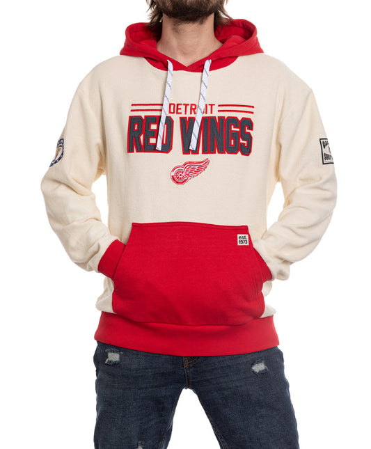 Person wearing a Detroit Red Wings hoodie on a white background