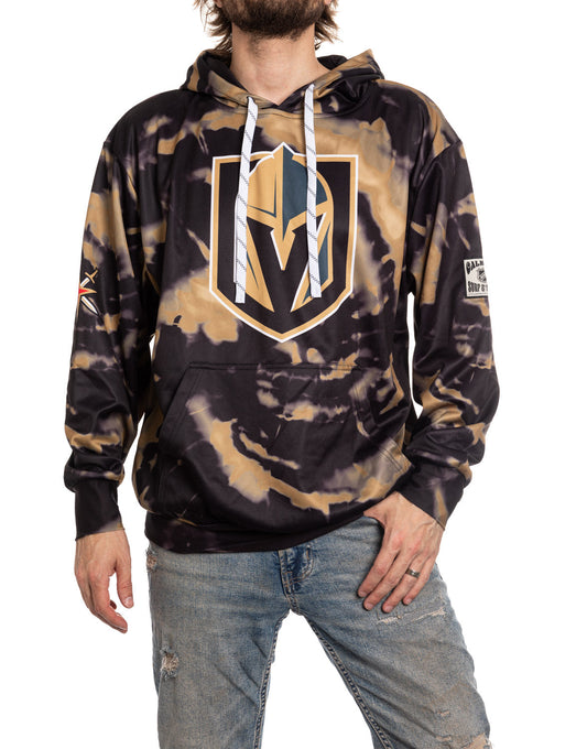 Person wearing a tie-dye hoodie with a logo on a white background