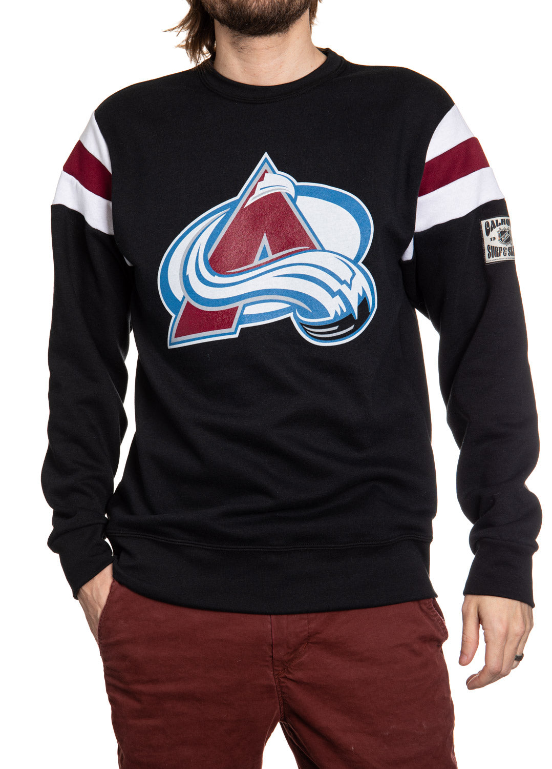 Black sweater with a sports team logo worn by a person on a white background