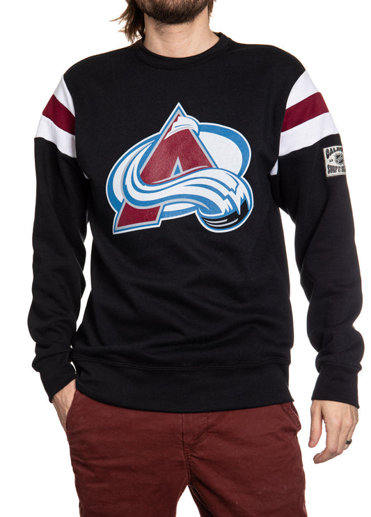 Black sweater with a sports team logo worn by a person on a white background